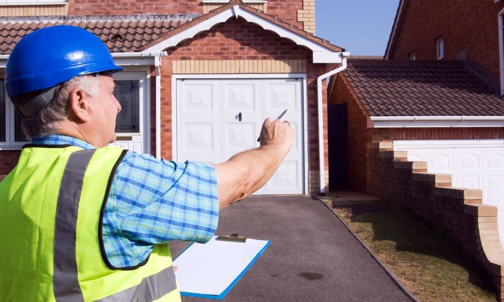 Property inspector in safety vest and hard hat taking notes in front of a residential home in Fort Myers