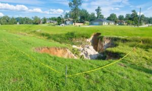 Flood elevation survey helps assess risks when a large sinkhole opens near a home
