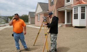 Surveyor measuring a house foundation for an elevation certificate