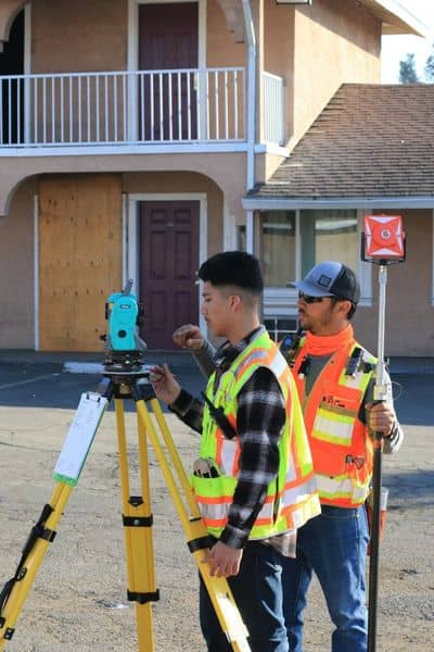 Surveyors measuring a property outside a residential home