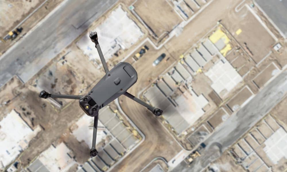 Drone land surveying over a construction site capturing aerial data for mapping and site planning
