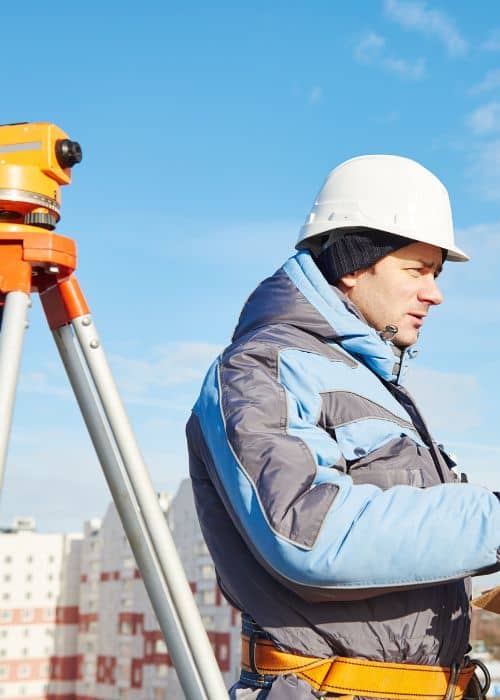 Licensed surveyors using equipment to measure property elevation for flood elevation surveys 
