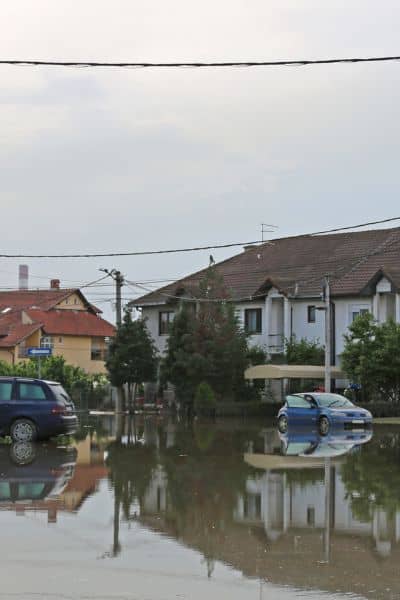 Flooded residential street showing why a property survey and elevation data are essential for FEMA flood zone challenges

