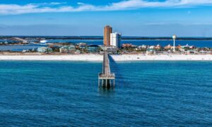 Aerial drone view of Pensacola Beach shoreline showing waves and coastal erosion highlighting the need for a property survey
