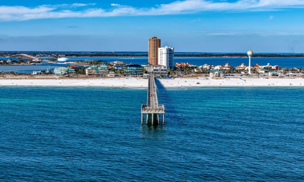 Aerial drone view of Pensacola Beach shoreline showing waves and coastal erosion highlighting the need for a property survey
