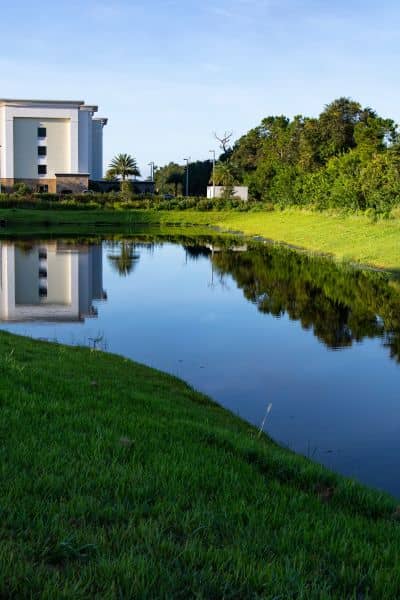 Detention pond stormwater design system - ALTA SURVEY Florida Detention pond beside a commercial building illustrating stormwater design and runoff control.