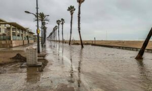 Flooded coastal streets showing rising water along a beachfront walkway.