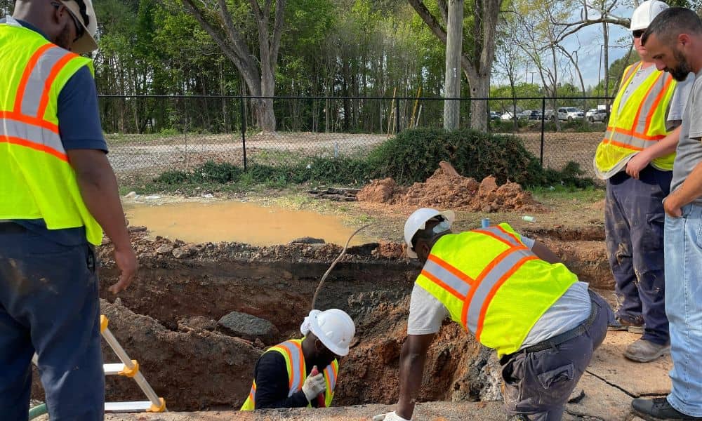 Due diligence survey easement utility work - ALTA SURVEY Florida Utility workers digging near a residential yard to show how a due diligence survey reveals easements and prevents surprises