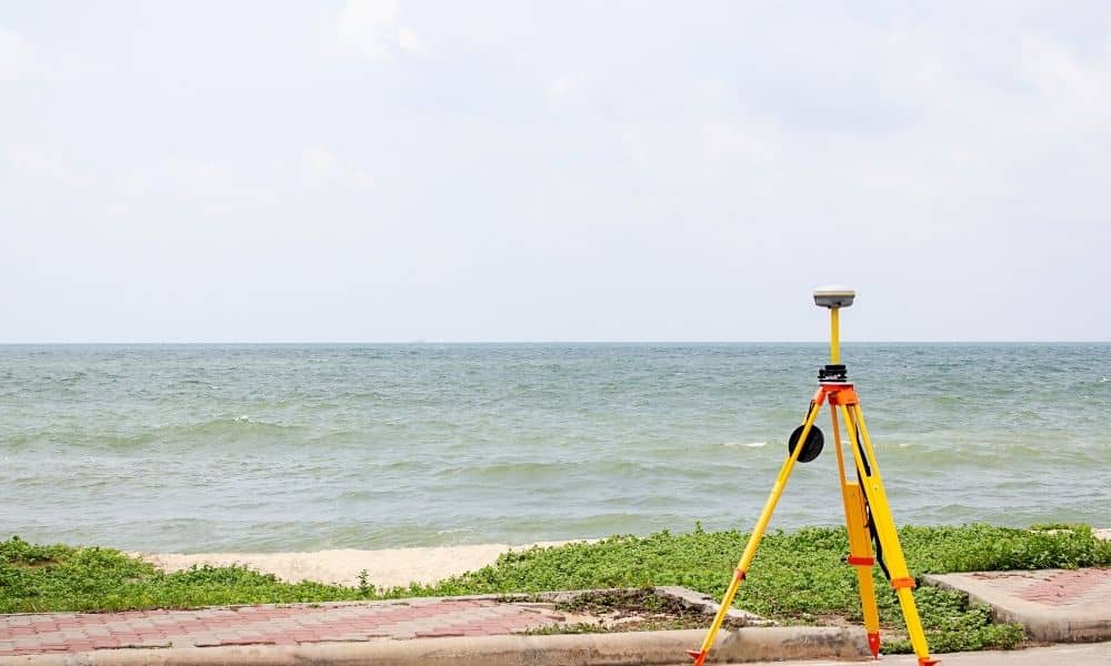 Survey equipment positioned near a shoreline to document a property boundary survey in a coastal area