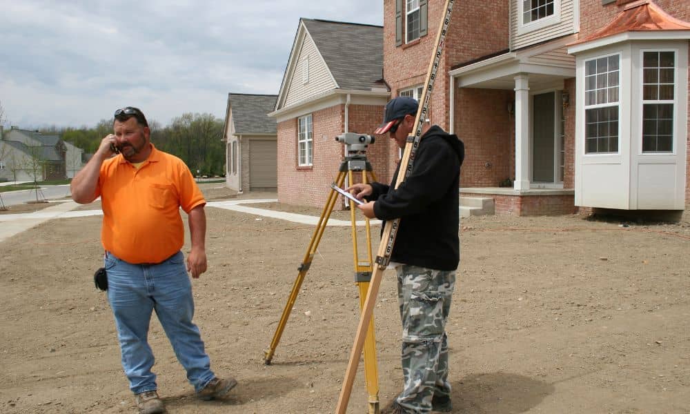 Surveyor measuring a house foundation for an elevation certificate