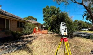 Residential land surveyor measuring property boundaries, a key factor in property survey cost