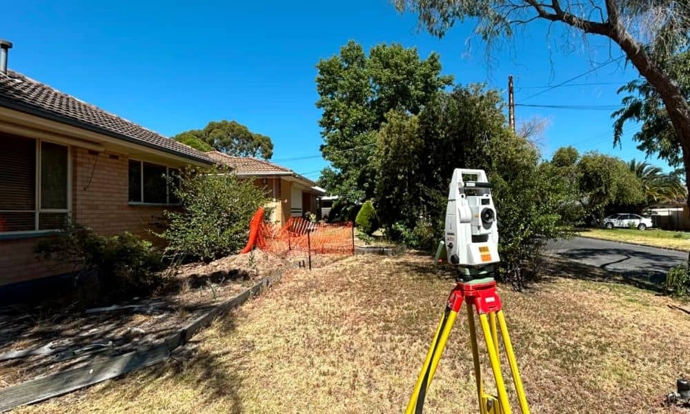 Residential land surveyor measuring property boundaries, a key factor in property survey cost