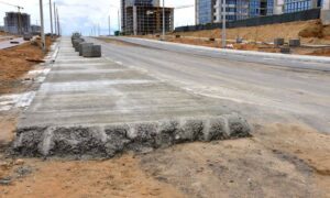 Construction site where roadwork has changed curb and ground levels, requiring a construction surveyor to check layout