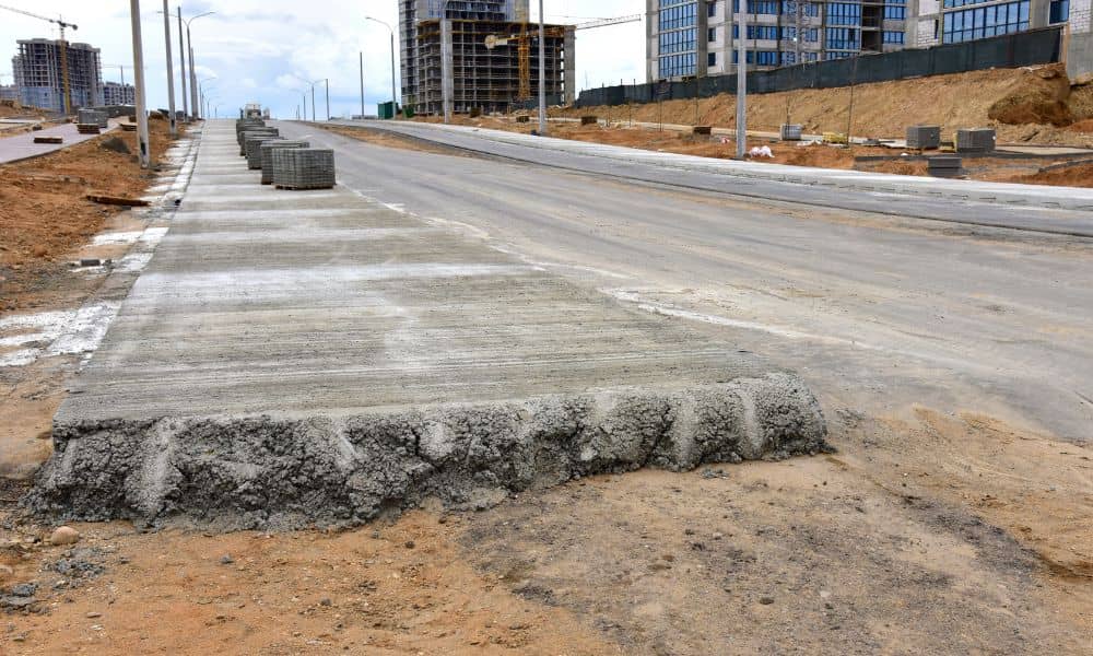 Construction site where roadwork has changed curb and ground levels, requiring a construction surveyor to check layout