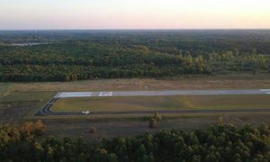 Aerial view of a private airstrip and surrounding property where a property survey may be needed before runway improvements