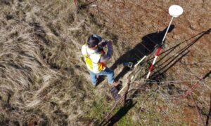 Surveyor conducting ALTA survey fieldwork for a commercial property refinance