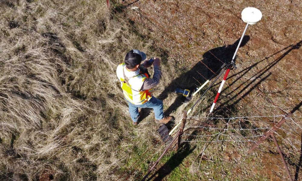 Surveyor conducting ALTA survey fieldwork for a commercial property refinance